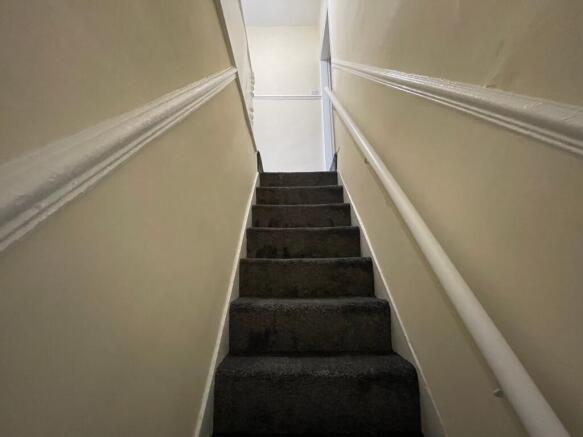 Bright staircase with soft neutral tones and ca...