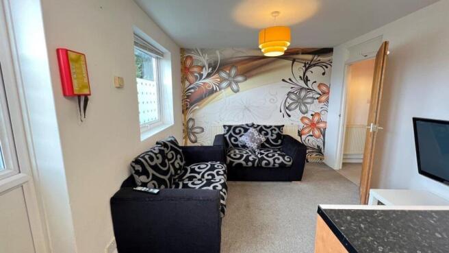 Bright living room with patterned feature wall ...