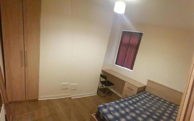 Neat furnished bedroom with wooden flooring, bu...