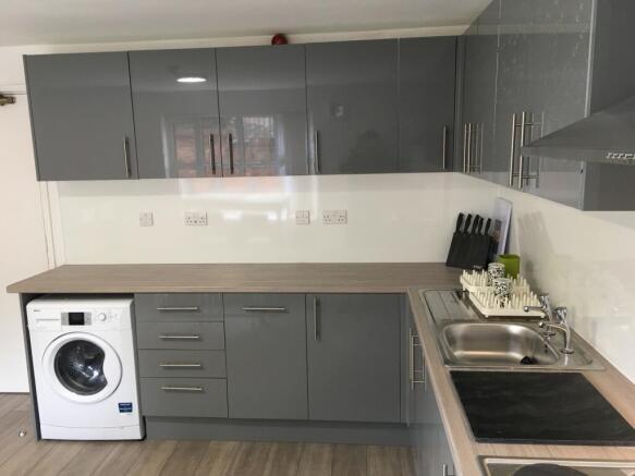 A modern and sleek kitchen featuring ample stor...