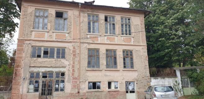 Detailed view of the building's exterior showing aged plaster and window frames