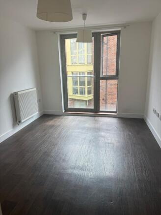 Bright room with floor-to-ceiling window and da...