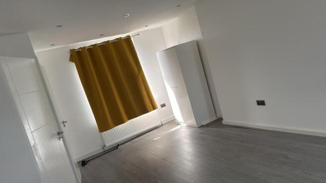 Bright bedroom with sleek wood-style flooring...