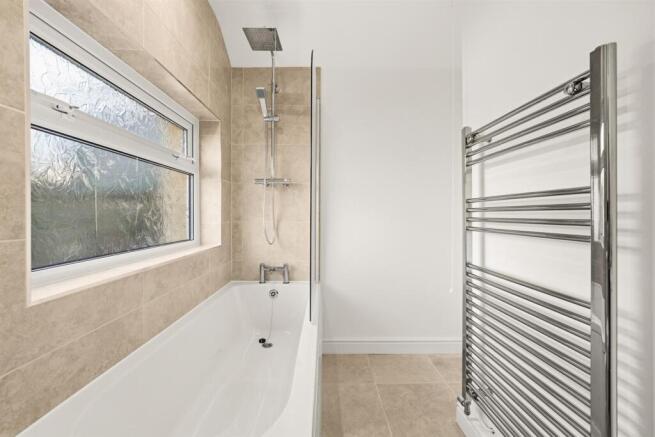 Pristine bathroom with rainfall shower and bath...