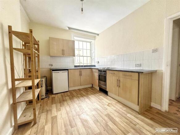 Bright kitchen with fitted units and wood floor...