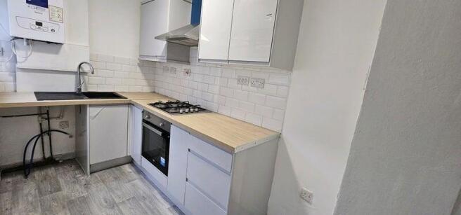 Modern kitchen with sleek white cabinets, wood-...