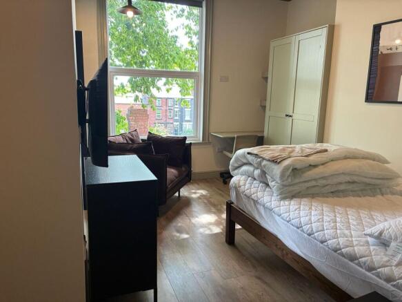 Bright bedroom with large window and study desk...