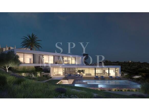 Luxury villa at night in Carvoeiro Algarve featuring modern exterior lighting illuminated swimming pool and large glass windows