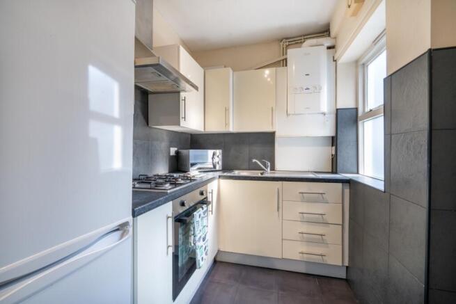 Bright, modern kitchen with integrated oven and...