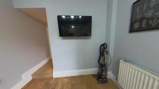 Neat living area with wood flooring, a wall-mou...