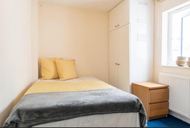 Cozy double bedroom featuring warm tones and am...