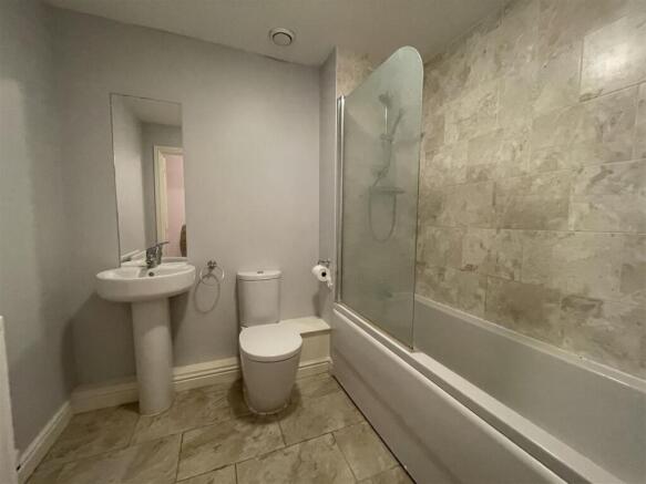 Modern bathroom with bath and tiled walls...