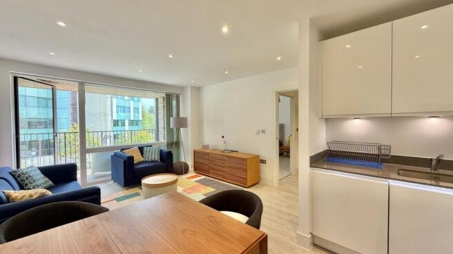 Bright open-plan living space with balcony view...