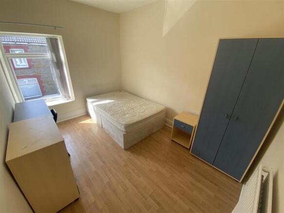 Bright bedroom with ample storage and wood floo...