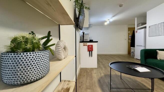 Bright, modern living area with light wood floo...