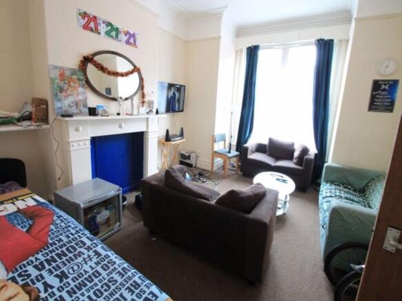 A cozy and well-lit single bedroom featuring a ...