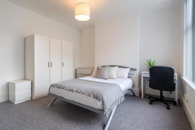 Bright, modern double bedroom with a comfortabl...