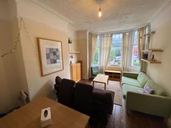 A bright and welcoming living room with large b...