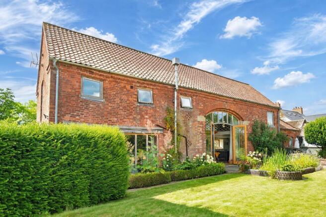 Timeless red brick architecture framed by mature planting