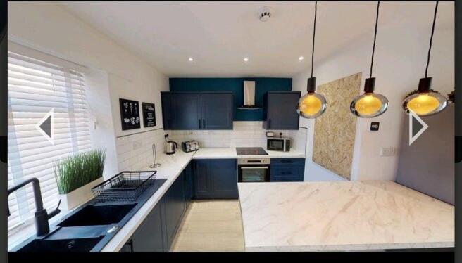A modern, stylish kitchen featuring sleek navy ...