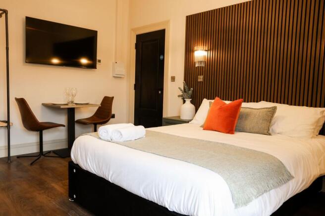 Sleek bedroom with feature wall and dining area...
