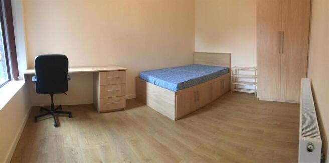 Bright bedroom with desk and ample storage spac...