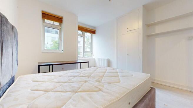 Bright bedroom with desk and built-in storage...
