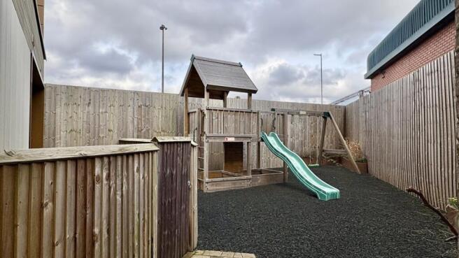 Enclosed outdoor play area with a timber play s...