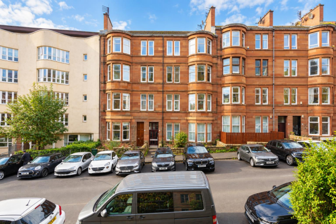Sunlit Sandstone Tenements and Parked Cars.png