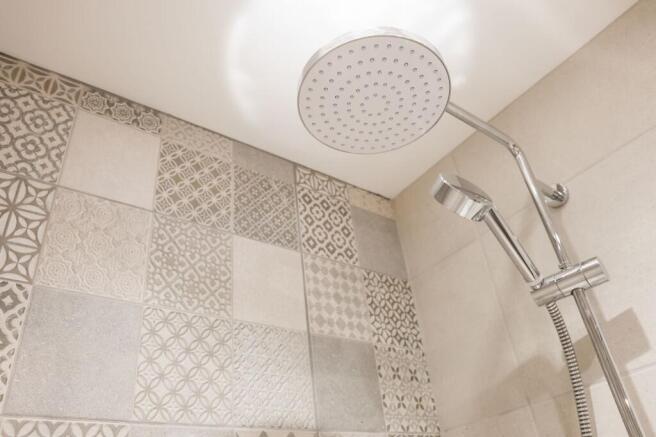 Stylish patterned-tile shower with rainhead...
