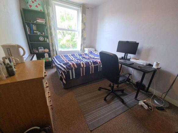 Bright, neatly arranged double bedroom with a d...