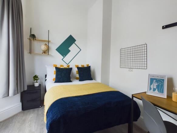 A bright and inviting double bedroom with styli...