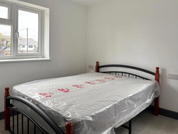 Bright, simply furnished bedroom with a metal-f...