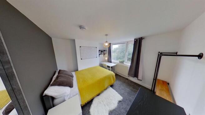 Bright modern bedroom with study desk and windo...