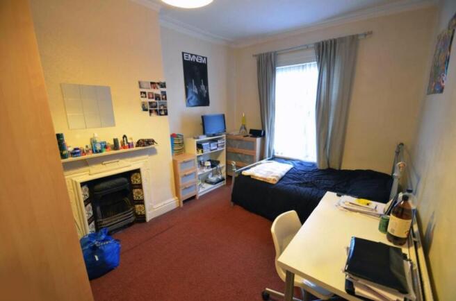 Neat furnished bedroom with a single bed, desk ...