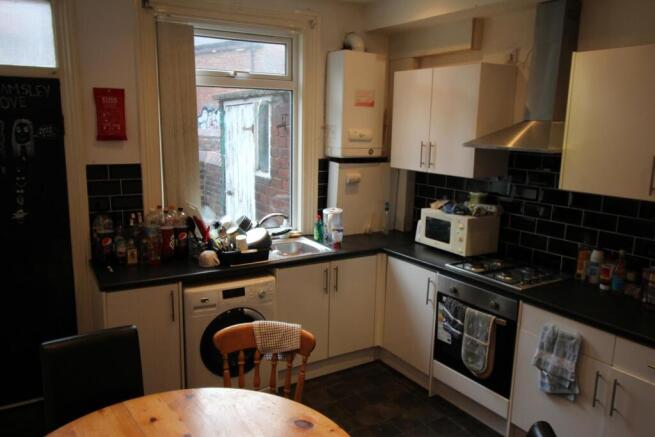 Bright kitchen with modern white cabinets, blac...