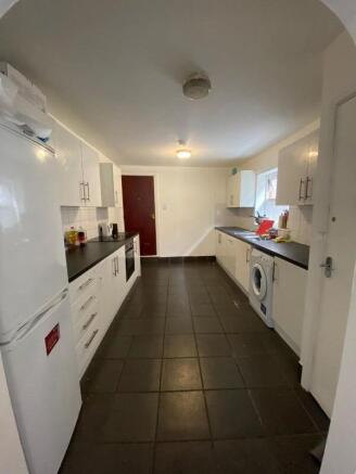 A spacious kitchen with white cabinetry and bla...