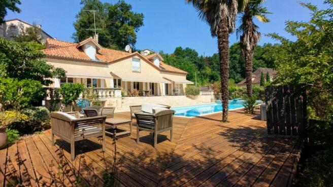 Une belle maison avec une terrasse en bois, des pa