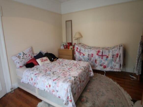 A spacious master bedroom featuring a cozy bed,...