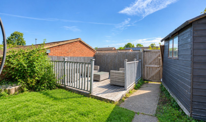 Sunny Garden Deck with Shed and Lush Lawn.png