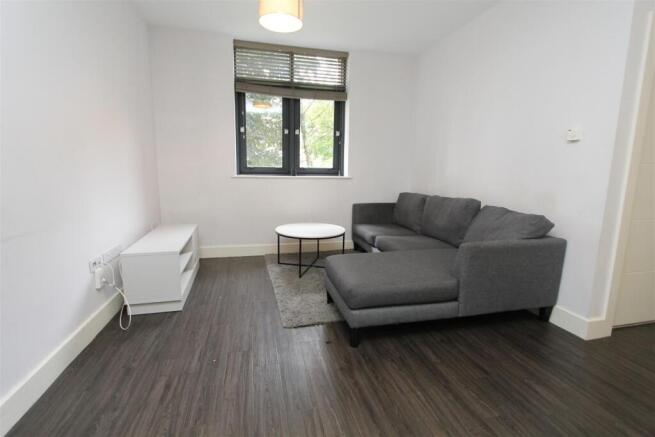 Bright lounge with sleek dark wood flooring...