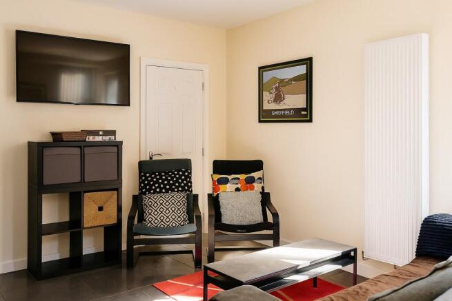 Bright, modern living room with wall-mounted TV...