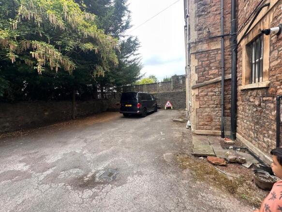 Private parking area beside a stone-built prope...