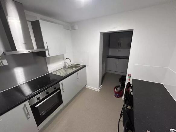 Modern galley kitchen with sleek white cupboard...