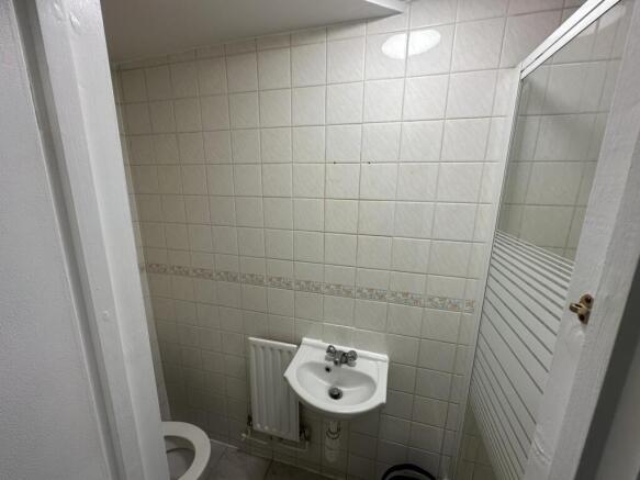 Compact bathroom with sink and tiled walls...