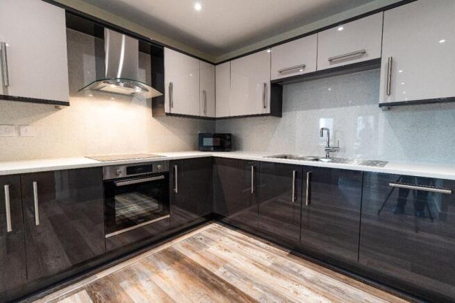 A modern kitchen featuring sleek black and grey...