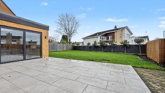 Well-maintained private garden with a paved pat...