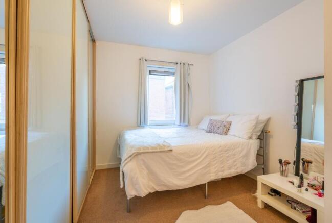 Bright, simply styled bedroom with a comfortabl...