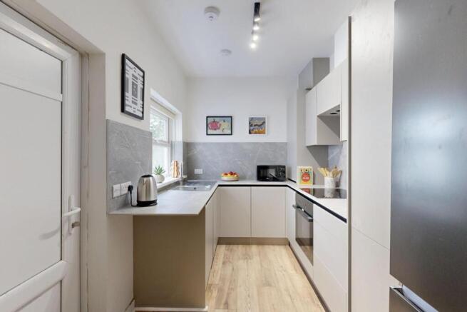 A modern, well-lit kitchen with white cabinets ...