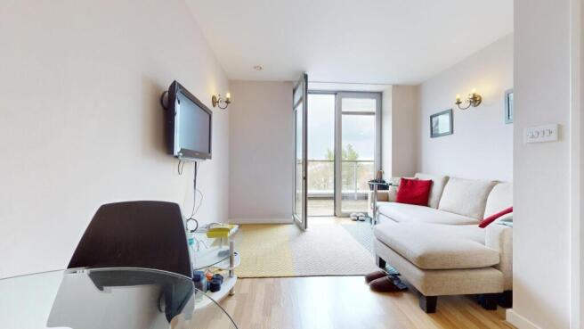 Bright living room with couch and balcony acces...